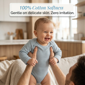 A smiling baby being held by a person in a cozy indoor setting.