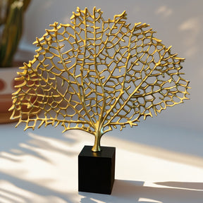 a golden sculpture of a tree, displayed on a black base.