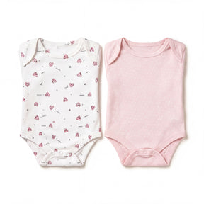 two baby onesies, one white with a pattern of hearts and one pink with polka dots, both laid out on a white background.