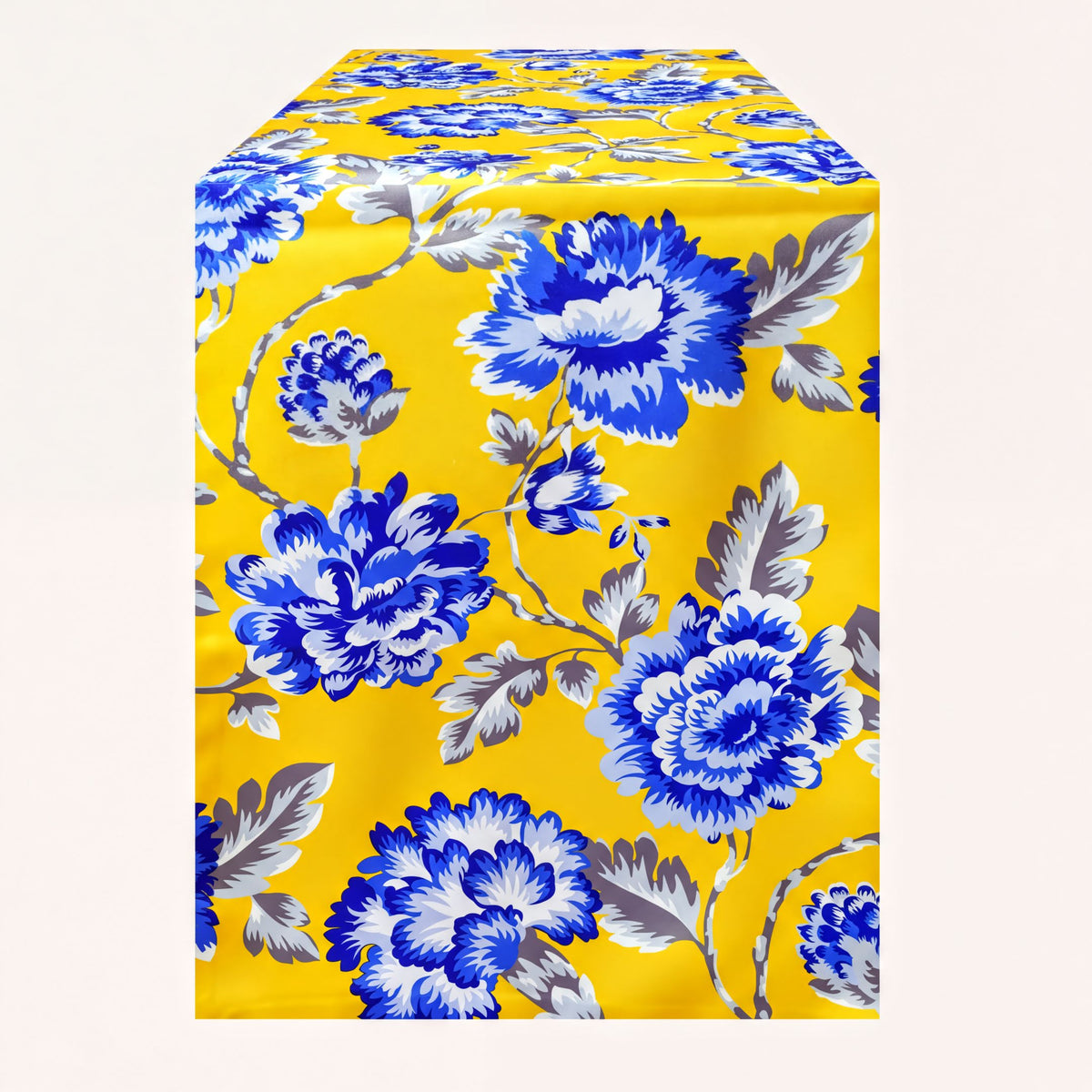 Printed yellow and blue table runner by RN-2, featuring colorful floral patterns on a fabric surface.