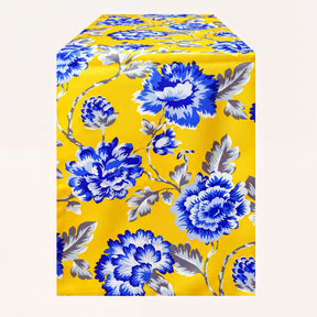 Printed yellow and blue table runner by RN-2, featuring colorful floral patterns on a fabric surface.