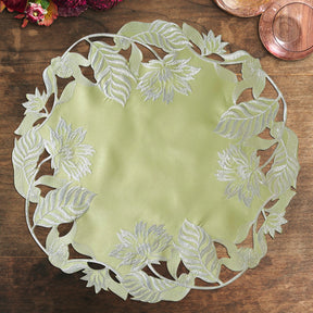 Set of four light green round linen doilies from The Daulton Collection, perfect for placemats and decorative table settings.