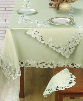 Set of four light green round linen doilies from The Daulton Collection, perfect for table decoration and protection.