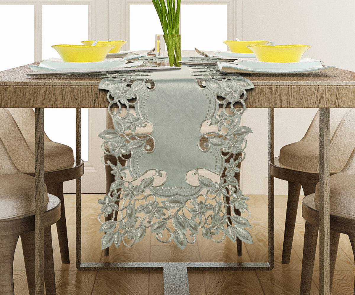 a dining table with a decorative table runner, yellow bowls, and a vase of green plants.