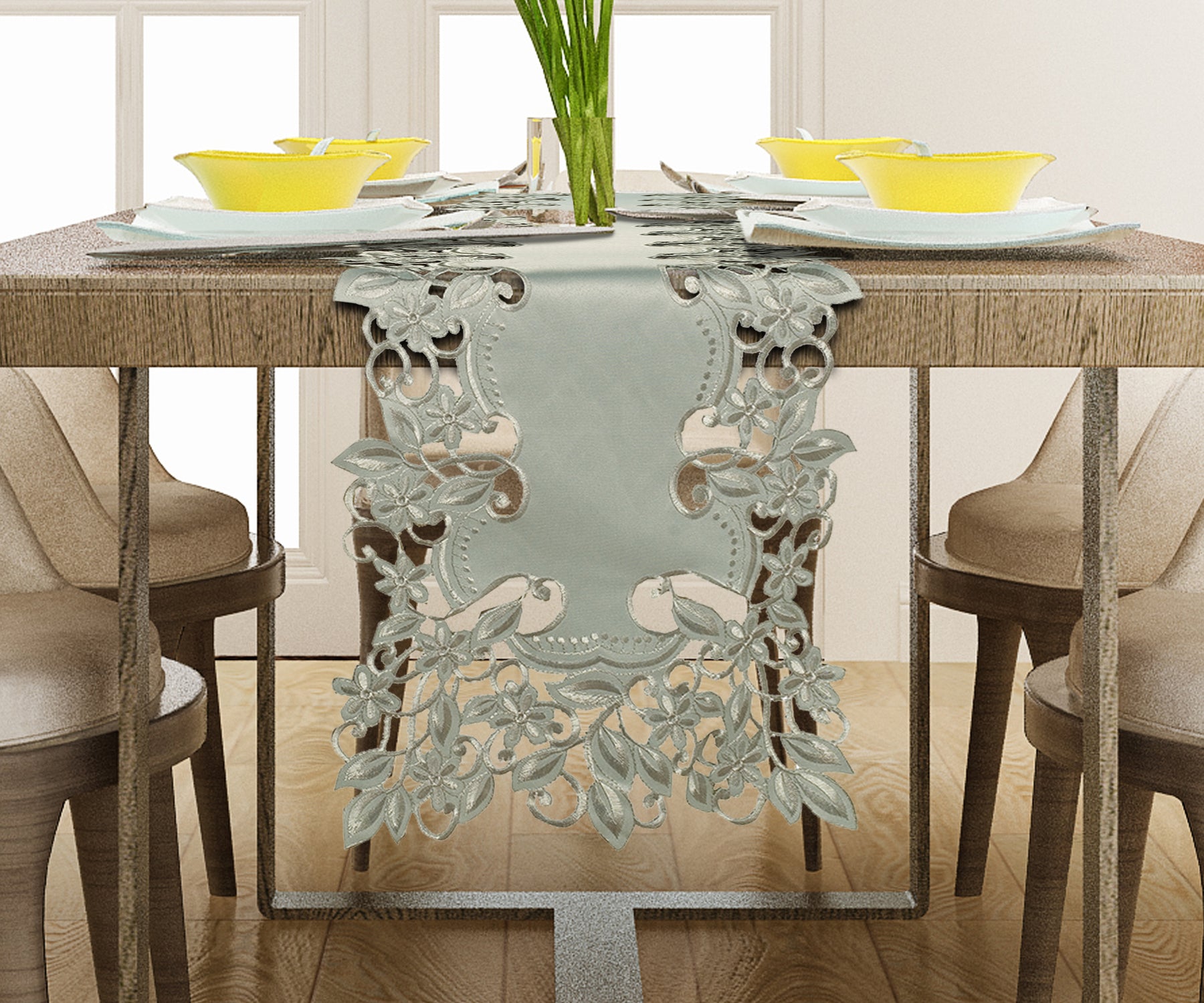a dining table with a decorative table runner, yellow bowls, and a vase of green plants.
