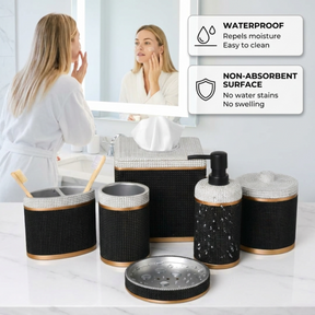a woman standing in front of a bathroom mirror, with a set of black and gold bathroom accessories placed on a countertop in front of her.