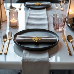 Set of four Ocean Majesty gold napkin rings featuring elegant sea horse design, perfect for luxurious dining table decor.